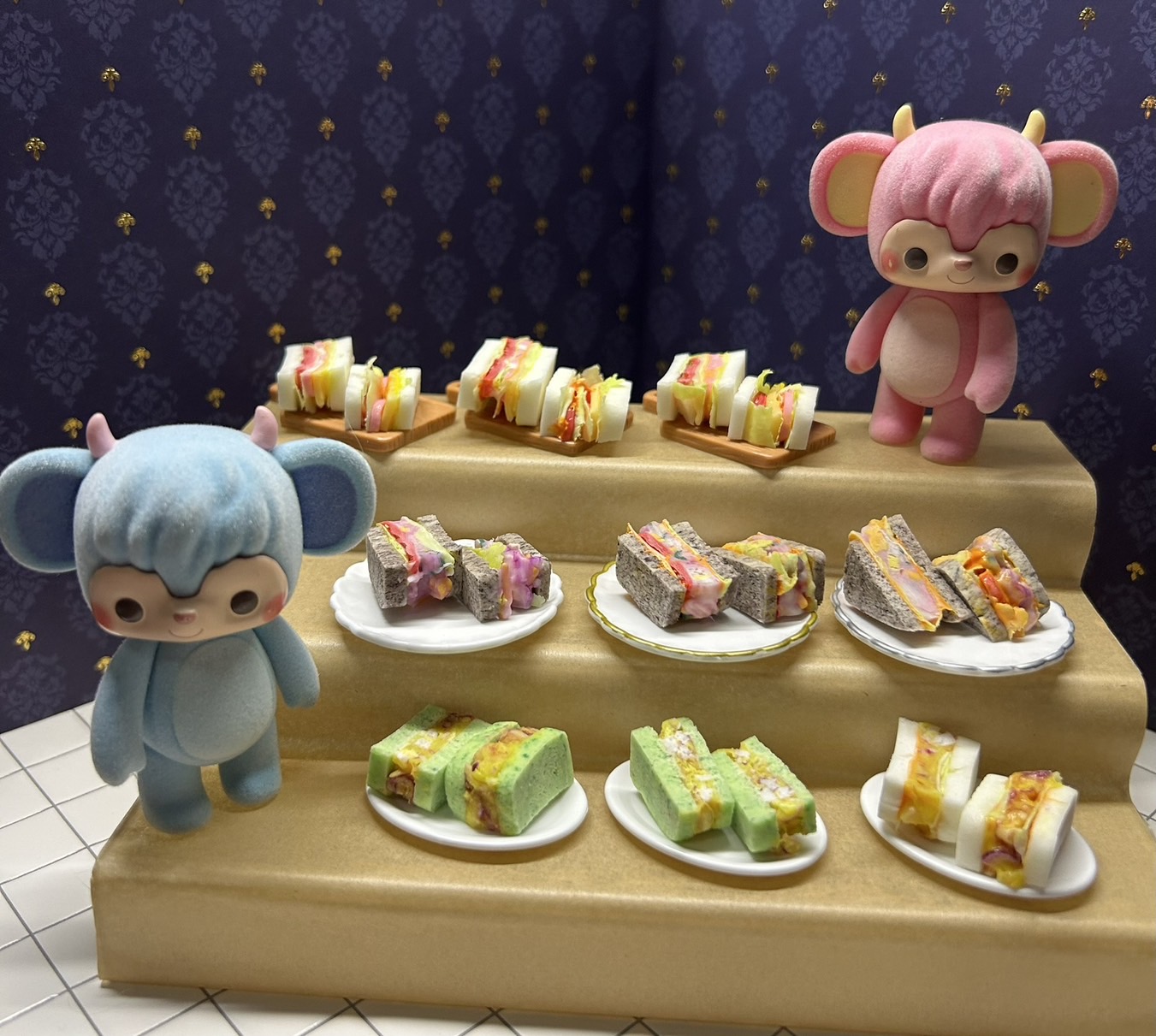お人形と一緒に並べられた、たくさんのミニチュアサンドイッチ