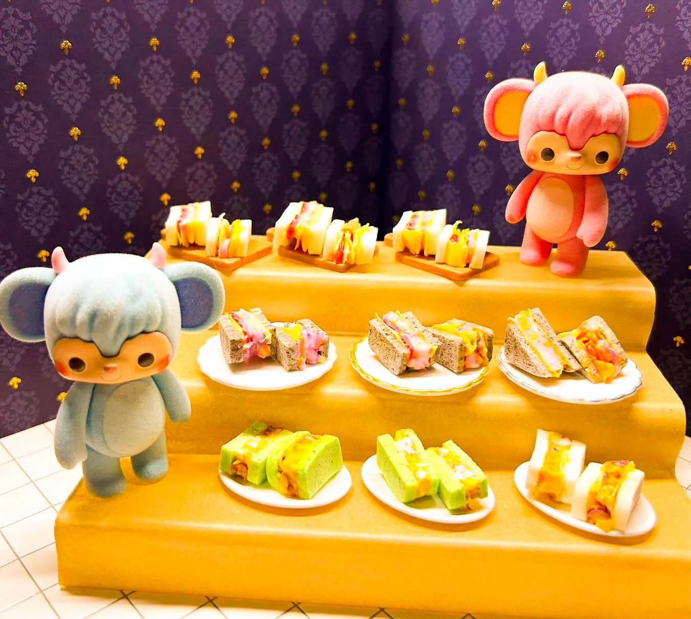 お人形と一緒に並べられた、たくさんのミニチュアサンドイッチ